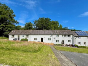 A two-story building with a sloped roof, solar panels on the roof, and a small front porch. - 3 bedroom accommodation in Kenmore, near Pitlochry (Kenmore, near Pitlochry)