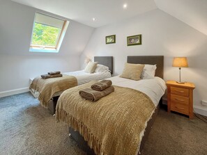 A hotel room with two beds, a window, a nightstand with a lamp, and two framed pictures on the wall. - 3 bedroom accommodation in Kenmore, near Pitlochry (Kenmore, near Pitlochry)