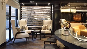 Ein stilvoller Lounge-Bereich mit Ledersofas, einer Holzverkleidung und Dekoration mit Geweihen.