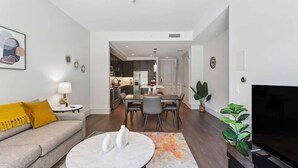 A modern living room with a sofa, coffee table, and TV. - The Preston Charm I Premium 1BR in Dallas (Dallas)