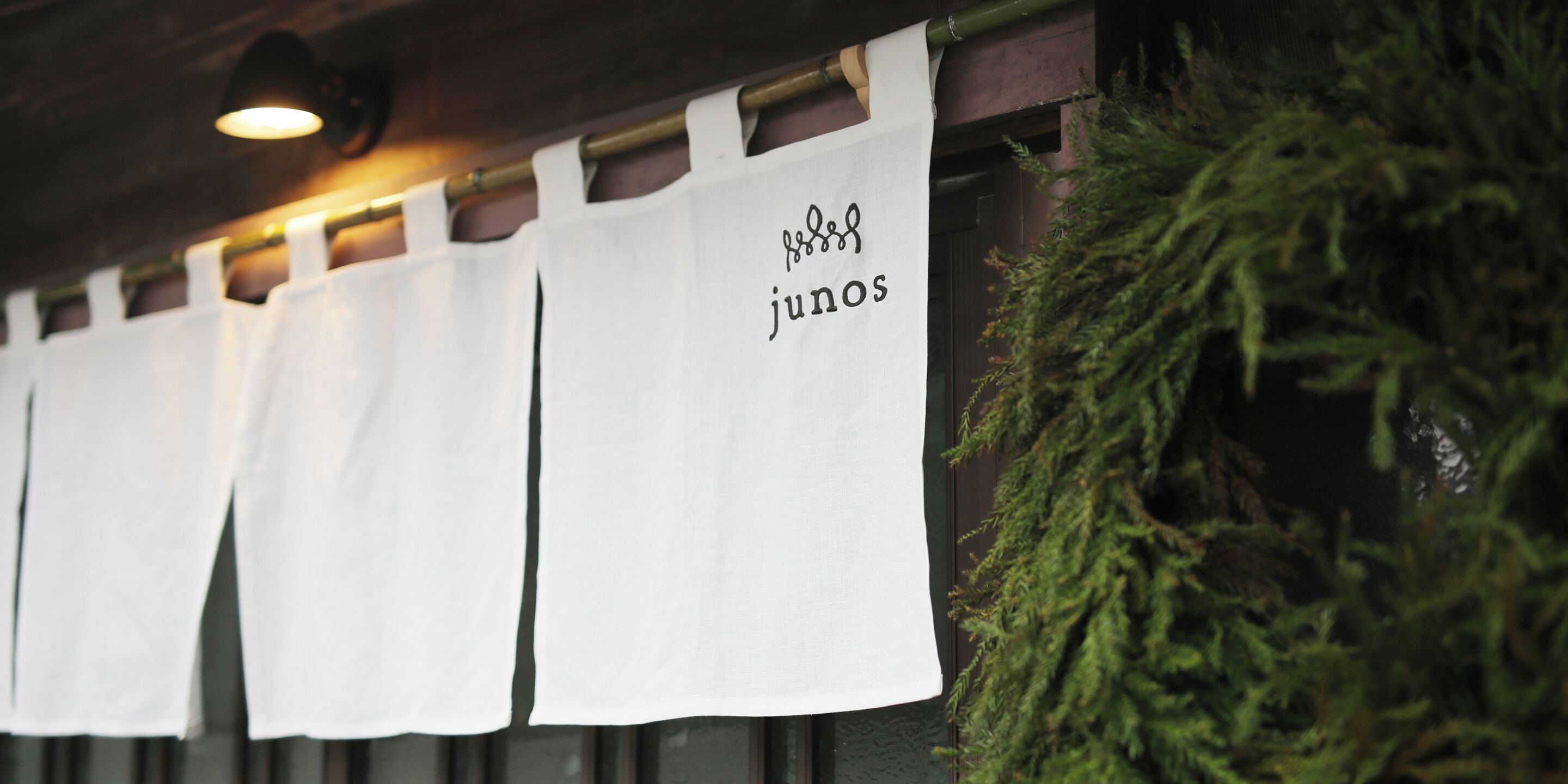 Filera d'avantals blancs penjats a la paret, amb el text "junos" visible en un d'ells.