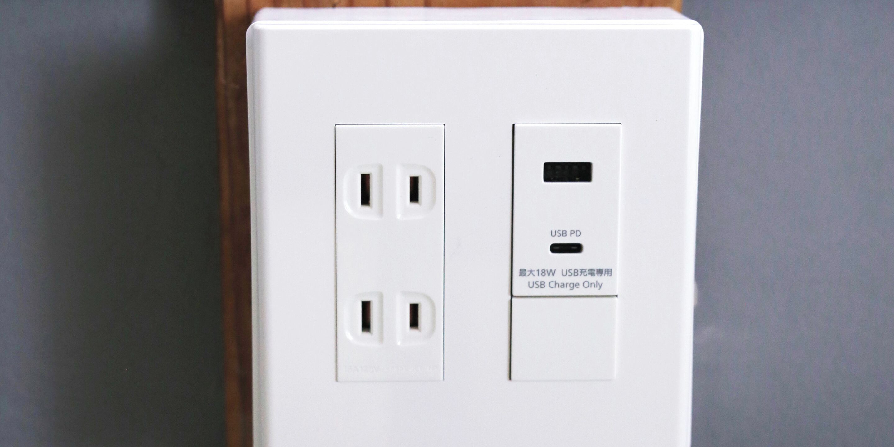 A white electrical outlet with two standard sockets and a USB port.