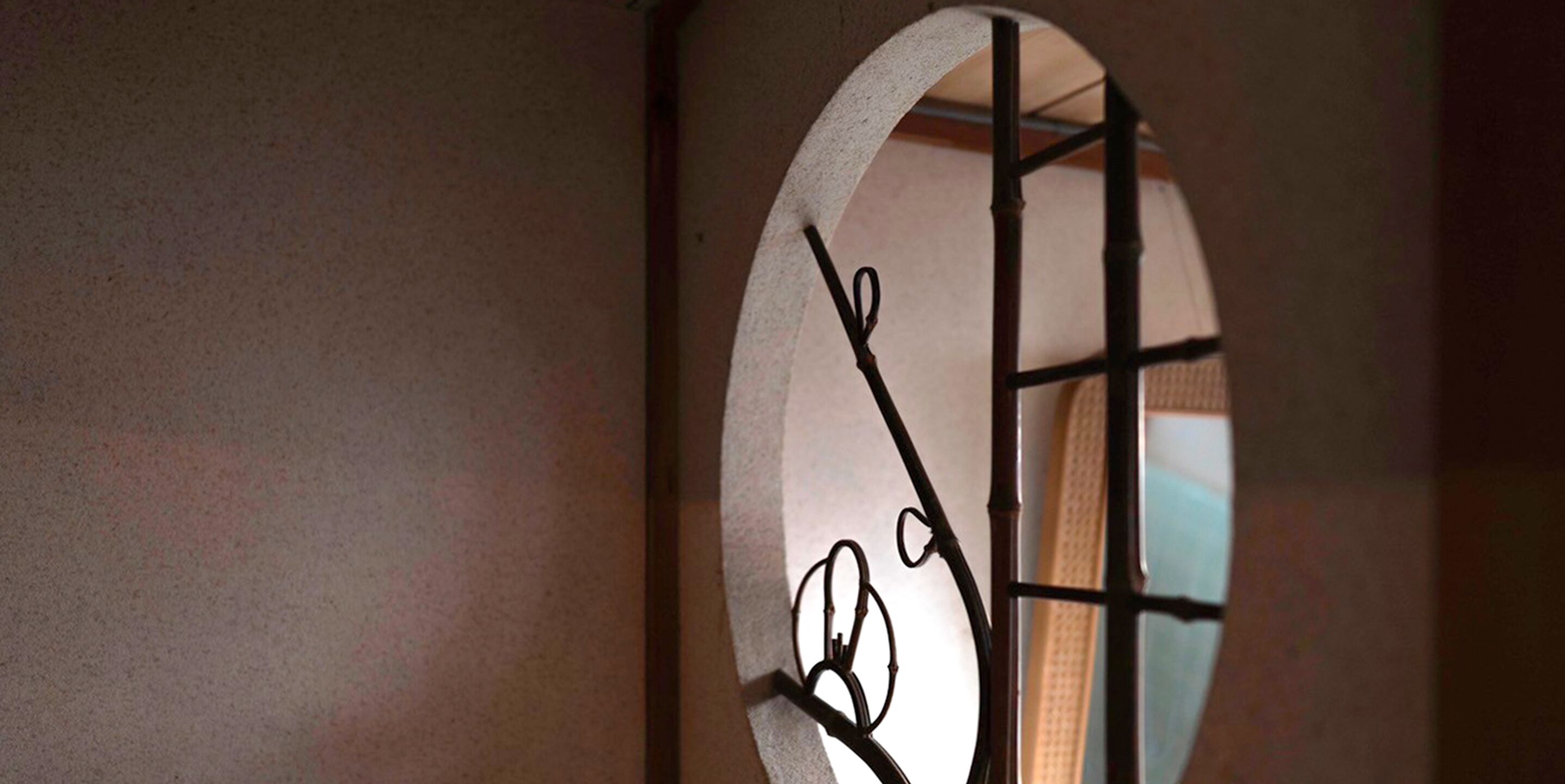 A circular window with a metal frame and a geometric design.
