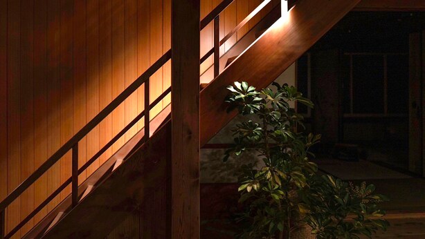 A wooden staircase with a railing, leading to a dark interior space. - junos (Nahari)