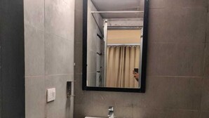 A bathroom with a white sink, a mirror, and a shower curtain.