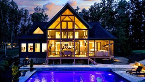 A large, modern house with a prominent attic and a swimming pool.