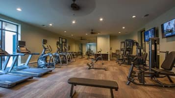 A gym with treadmills, elliptical machines, and weight equipment.