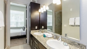 A modern bathroom with two sinks, a large mirror, and a walk-in shower. - Peony At Millennium - Elegant 2 BDR in Houston (Houston)