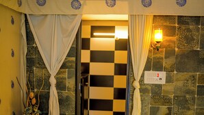 A bathroom with a checkered floor, patterned walls, and a light fixture. - Polki Farm Resort Jawai -Sumerpur (Sumerpur)