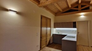 A compact kitchen with wooden cabinets, a countertop, and a built-in sink.