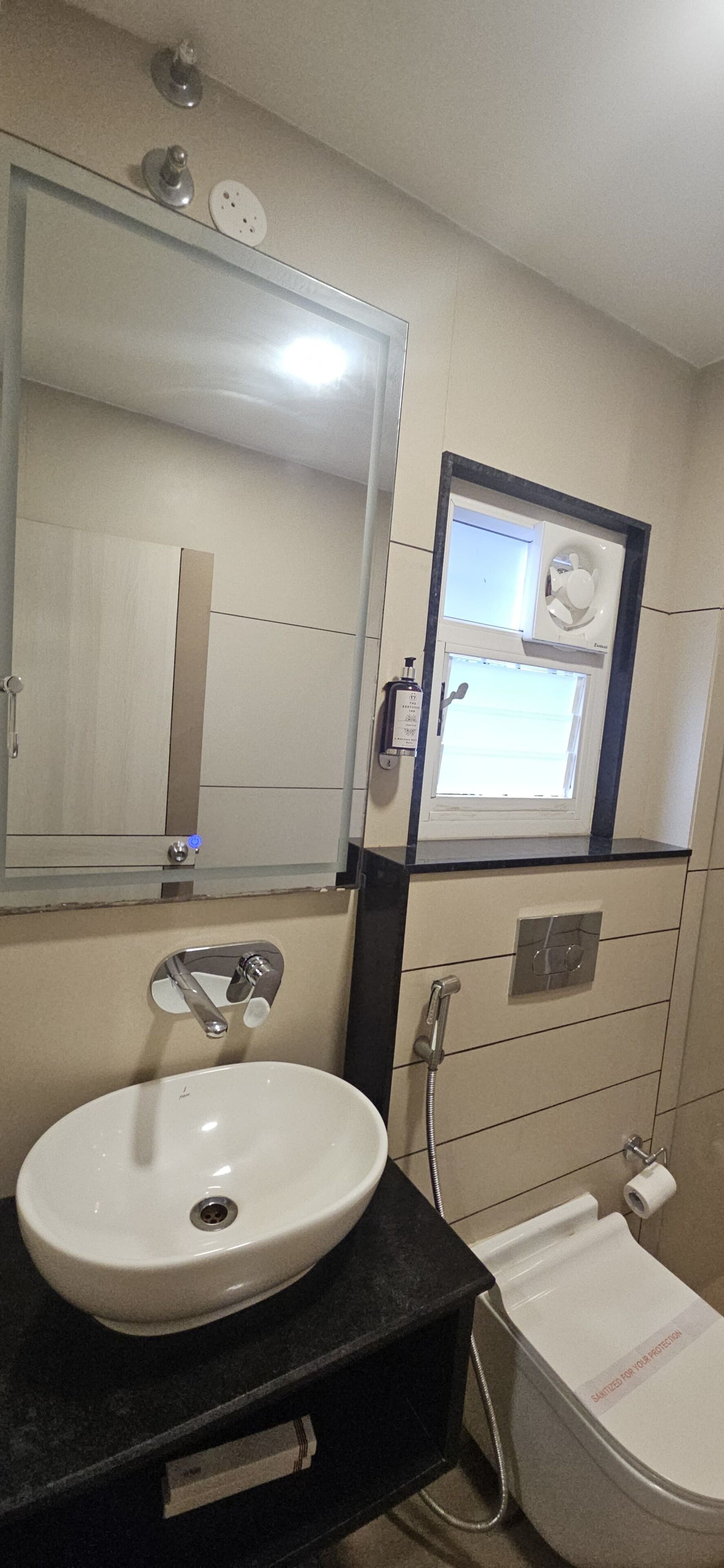Une salle de bain avec un lavabo, un miroir et des toilettes.