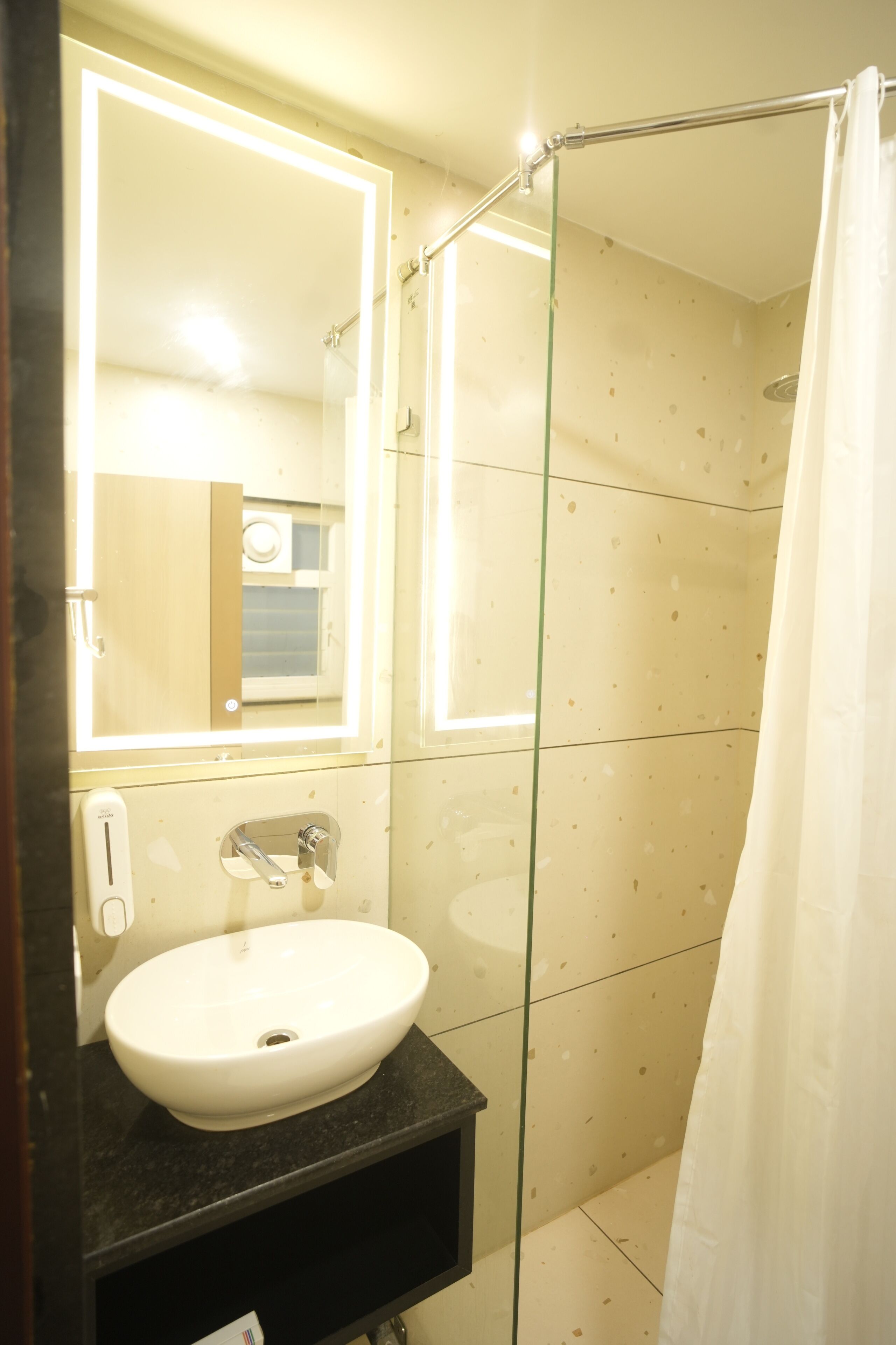 A bathroom with a white sink, a mirror, and a glass shower enclosure.
