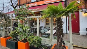 A Mediterranean Meze Grill restaurant with outdoor seating and potted plants.