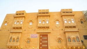 A building with ornate architectural details, a sign for Hotel Samrise, and multiple windows with intricate designs. - Hotel Vista fort (Jaisalmer)
