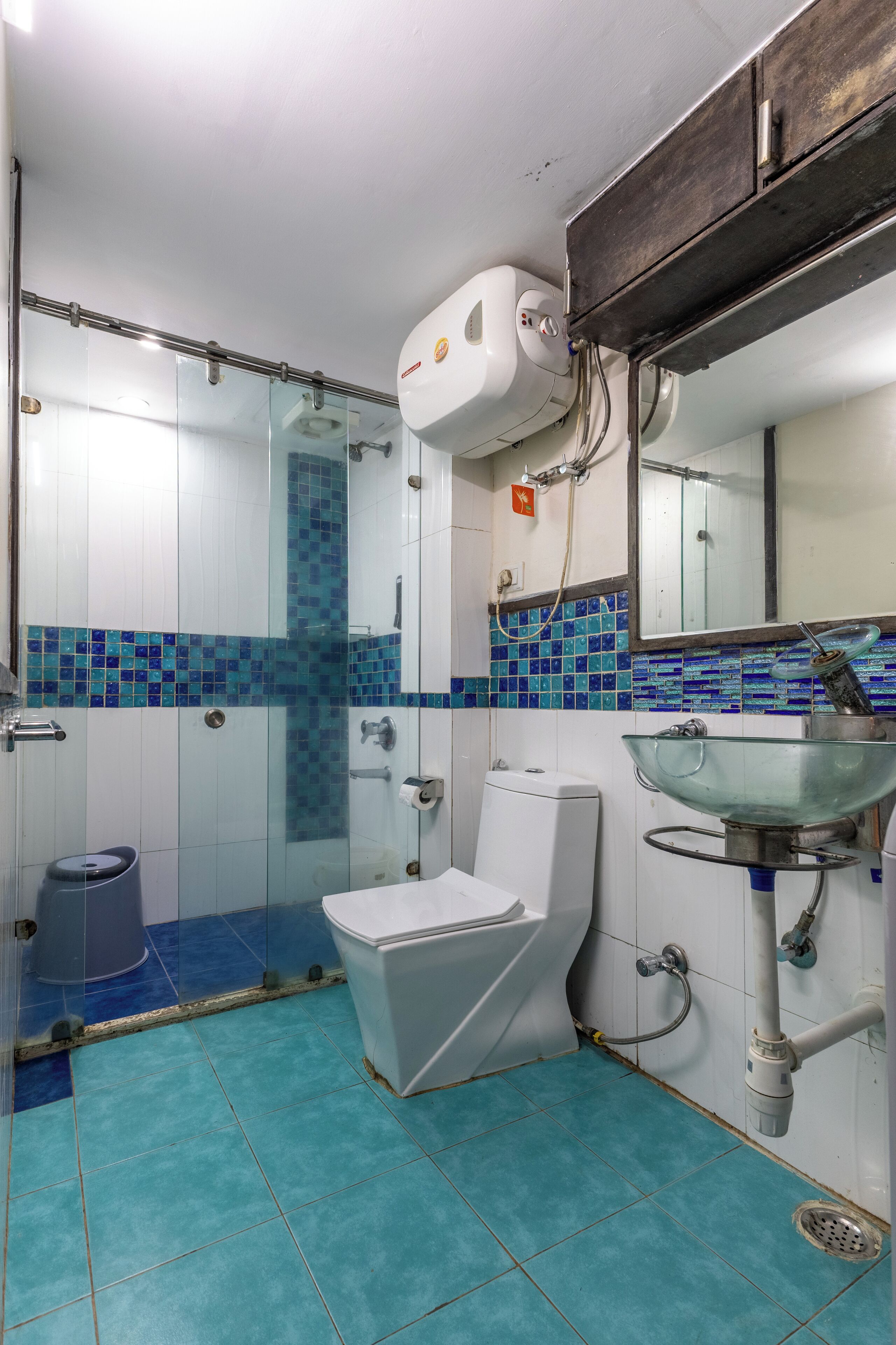 A bathroom with a toilet, sink, and shower area.