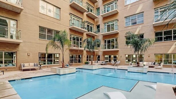 A multi-story building with a central swimming pool, outdoor seating, and balconies. - Comfort at the Star I 2 Bed Apt in Houston (Houston)