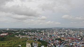 A cityscape with a mix of residential and commercial buildings, a prominent church, and a large open field in the foreground.