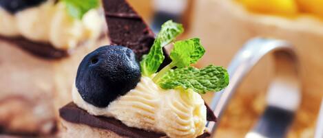 Un dessert con gelato al cioccolato e alla vaniglia, guarnito con mirtilli e foglie di menta.