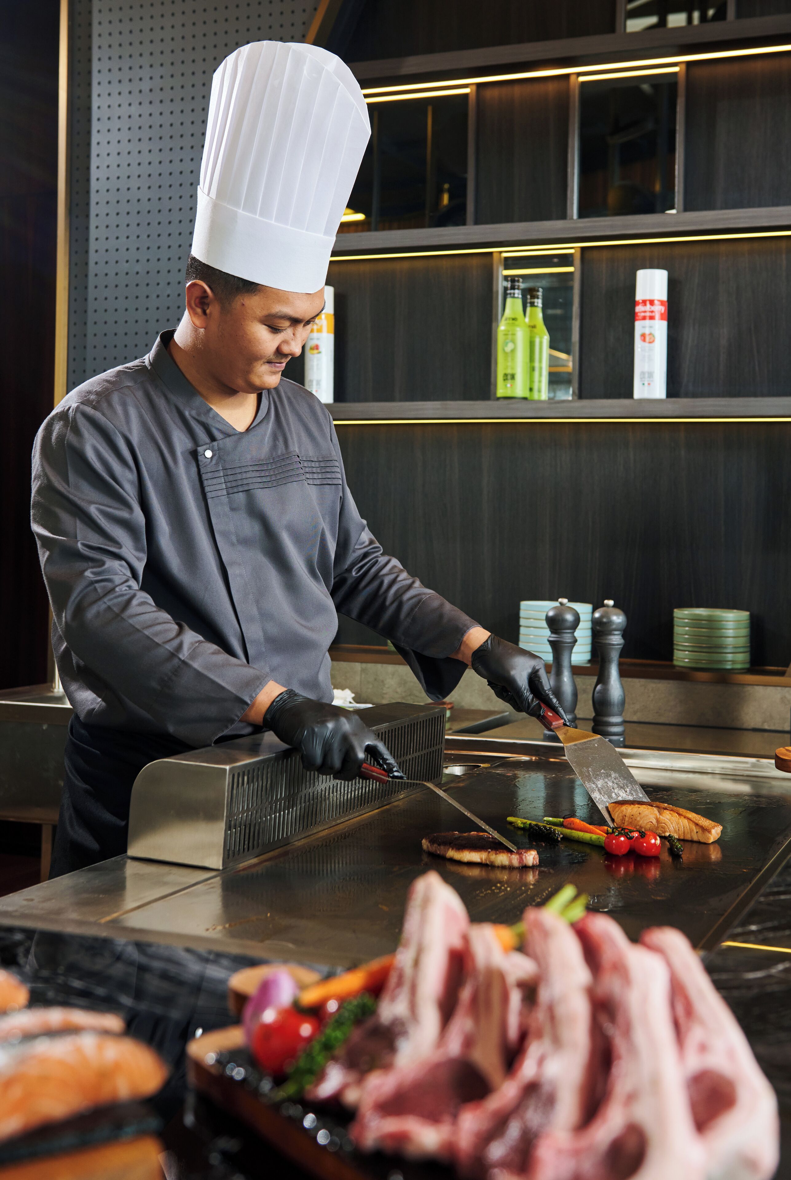 A chef preparing food at a counter with various ingredients and kitchen tools.
