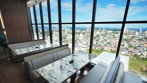 A modern interior with a large window offering a city view. - TRIMULIA Hotel (Sihanoukville)