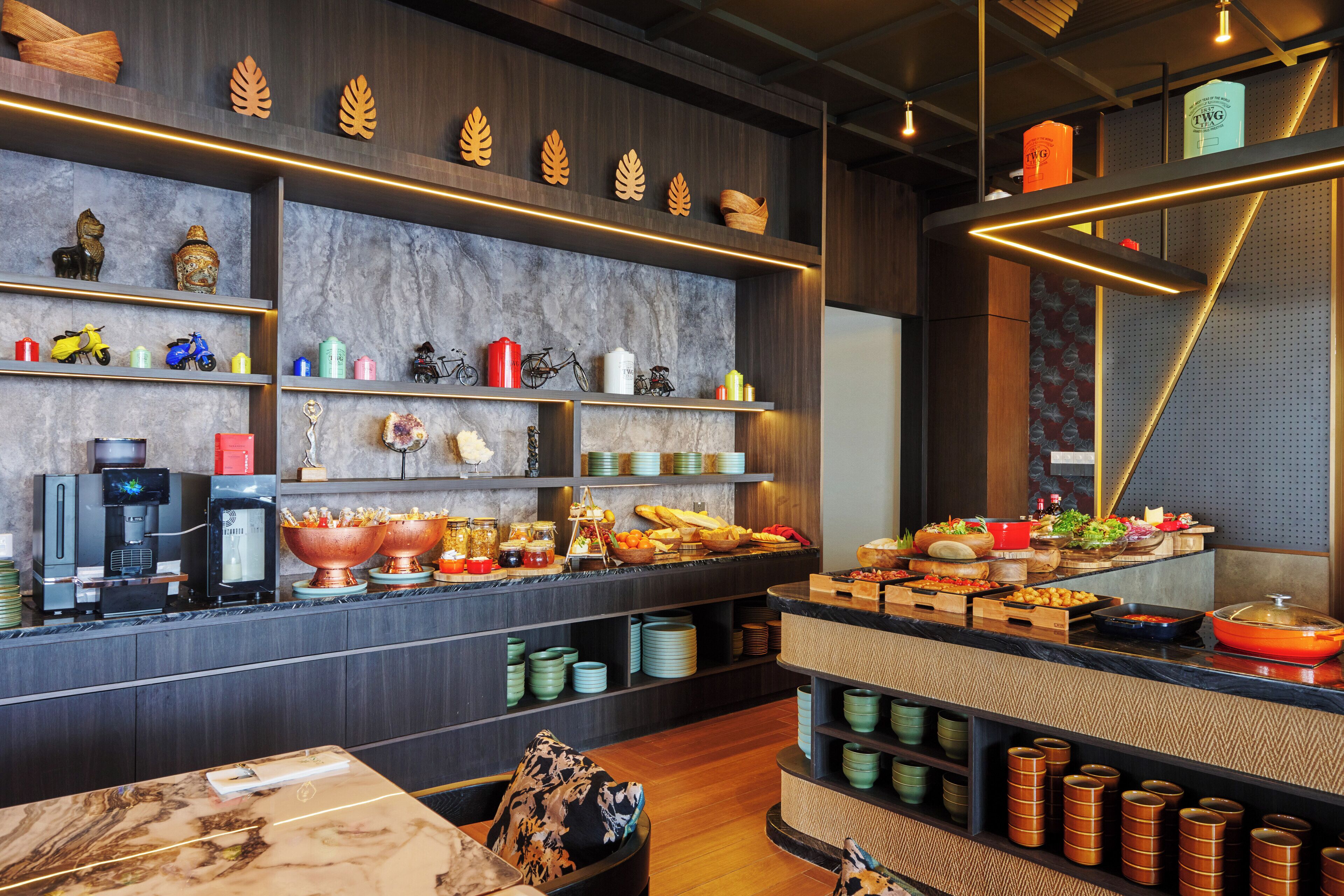 A modern kitchen with marble countertops, a coffee machine, and various kitchen utensils.