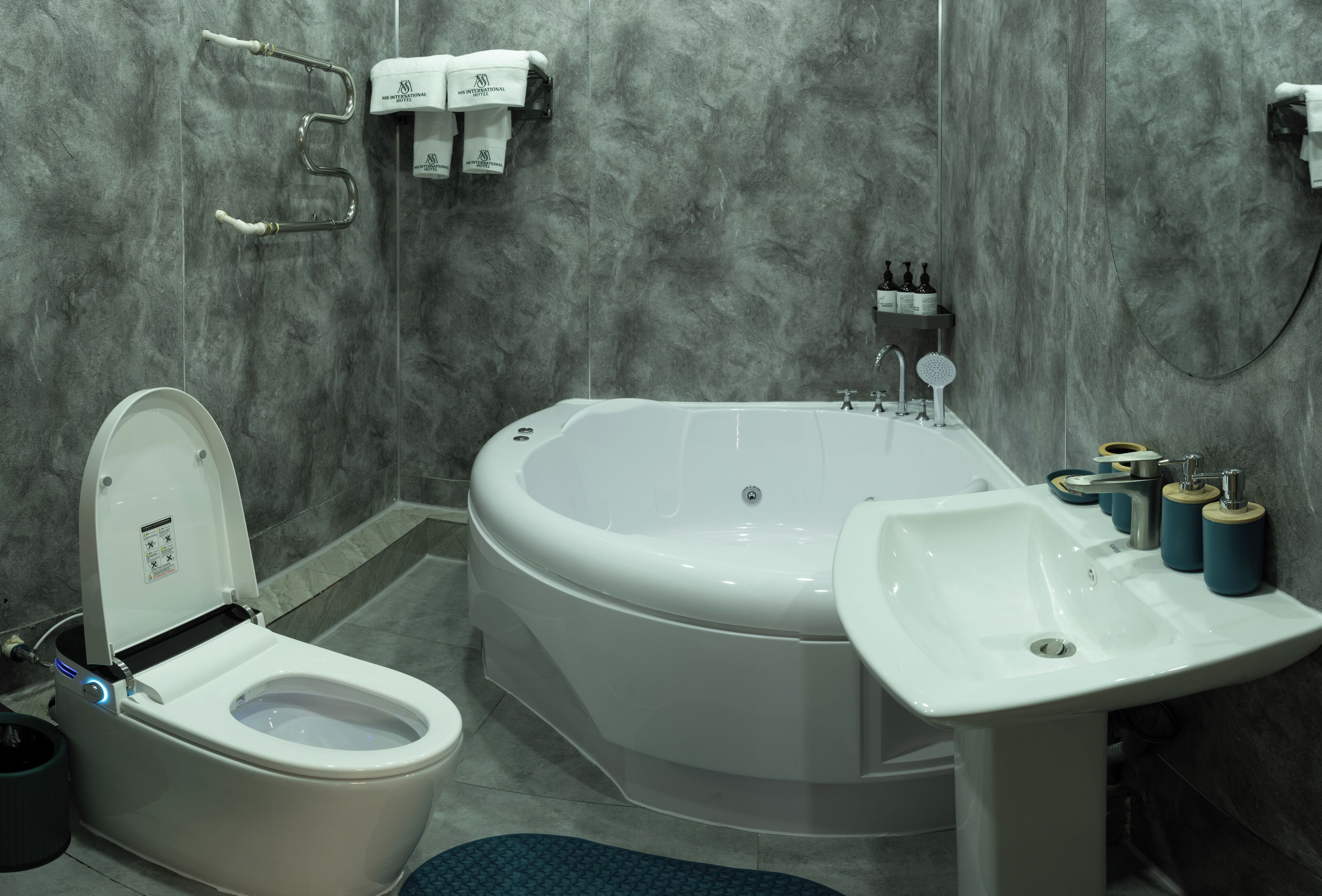 A modern bathroom with a toilet, a bathtub, and a sink.