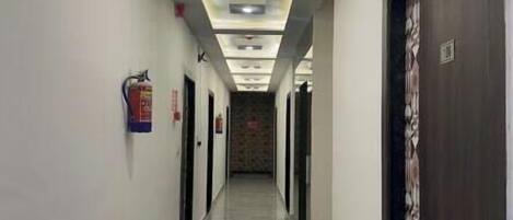 A long, narrow hallway with a polished marble floor and recessed lighting.