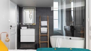 A modern bathroom with a bathtub, a mirror, and a towel rack. - DIFY Roi Lyon - Hotel de Ville (Lyon)