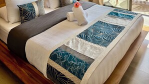 A hotel room with a large bed, a wooden headboard, a ceiling fan, and a view of the garden through a sliding glass door. - Bora Bora, Otemanu lagoon F2 with lagoon view (Anau bora bora)