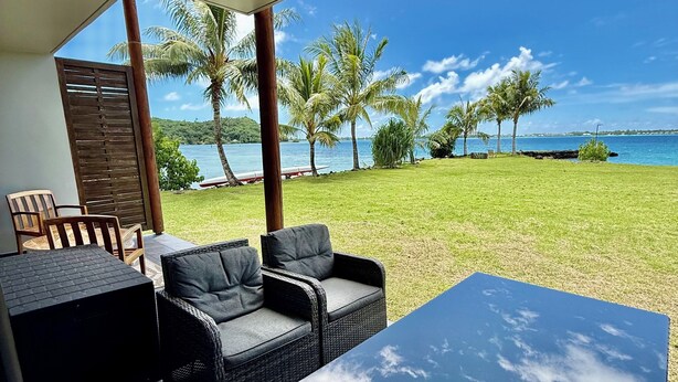 A patio with a table and chairs, a view of the sea, and palm trees. - Bora Bora, Otemanu lagoon F2 with lagoon view (Anau bora bora)