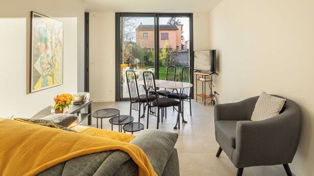 A modern living room with a sofa, a dining table with chairs, and a TV. - DIFY Stoppa - Parilly (Vénissieux)