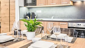 Une cuisine moderne avec des meubles en bois, un four à micro-ondes encastré et un four en acier inoxydable.