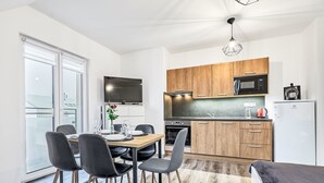 Moderni keittiö, jossa on puiset kaapit, mikroaaltouuni ja jääkaappi.