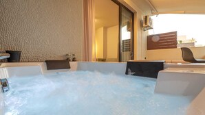Un jacuzzi con vista a un edificio y una silla.