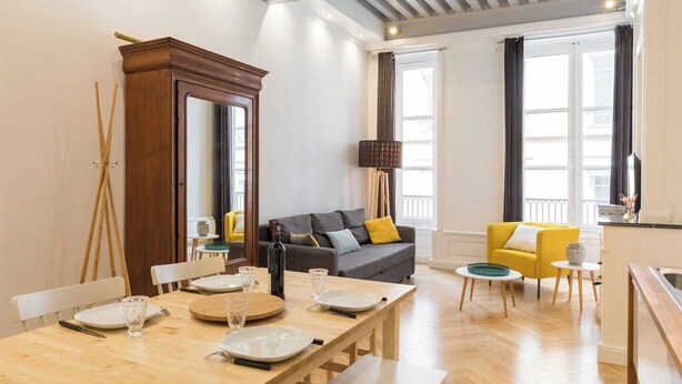A modern living room with a dining area, a sofa, and a yellow armchair. - DIFY Lovely - Centre-ville (Lyon)