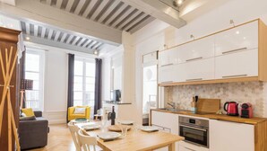 A modern kitchen with white cabinets, a wooden countertop, and a built-in oven. - DIFY Lovely - Centre-ville (Lyon)