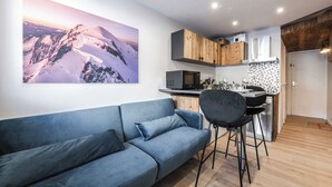 Une cuisine moderne avec des meubles en bois, un four à micro-ondes et un revêtement mural en carreaux.