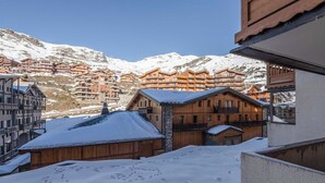 Une ville de montagne enneigée, avec des bâtiments en bois et un ciel dégagé.