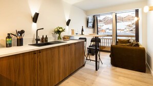 Een moderne keuken met een houten aanrecht, een spoelbak en een eethoek met een bank en stoelen.
