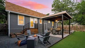 A covered patio area with outdoor seating and a fire feature. - Casa Que Canta by AvantStay | Private Pool, Firepit & Walkable East Austin Gem (Austin)