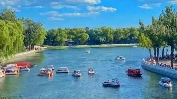 A river with boats and trees along the banks. - Beijing Gu Xiang 20 Hutong Culture Hotel (Beijing)