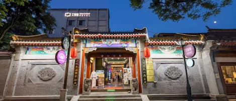 A traditional Chinese building with a sign for '艾丽娜 Boutique Hotel' at the entrance.