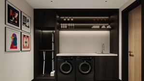 A compact laundry room with two washing machines, a sink, and a shelf with bottles. - Beijing Gu Xiang 20 Hutong Culture Hotel (Beijing)