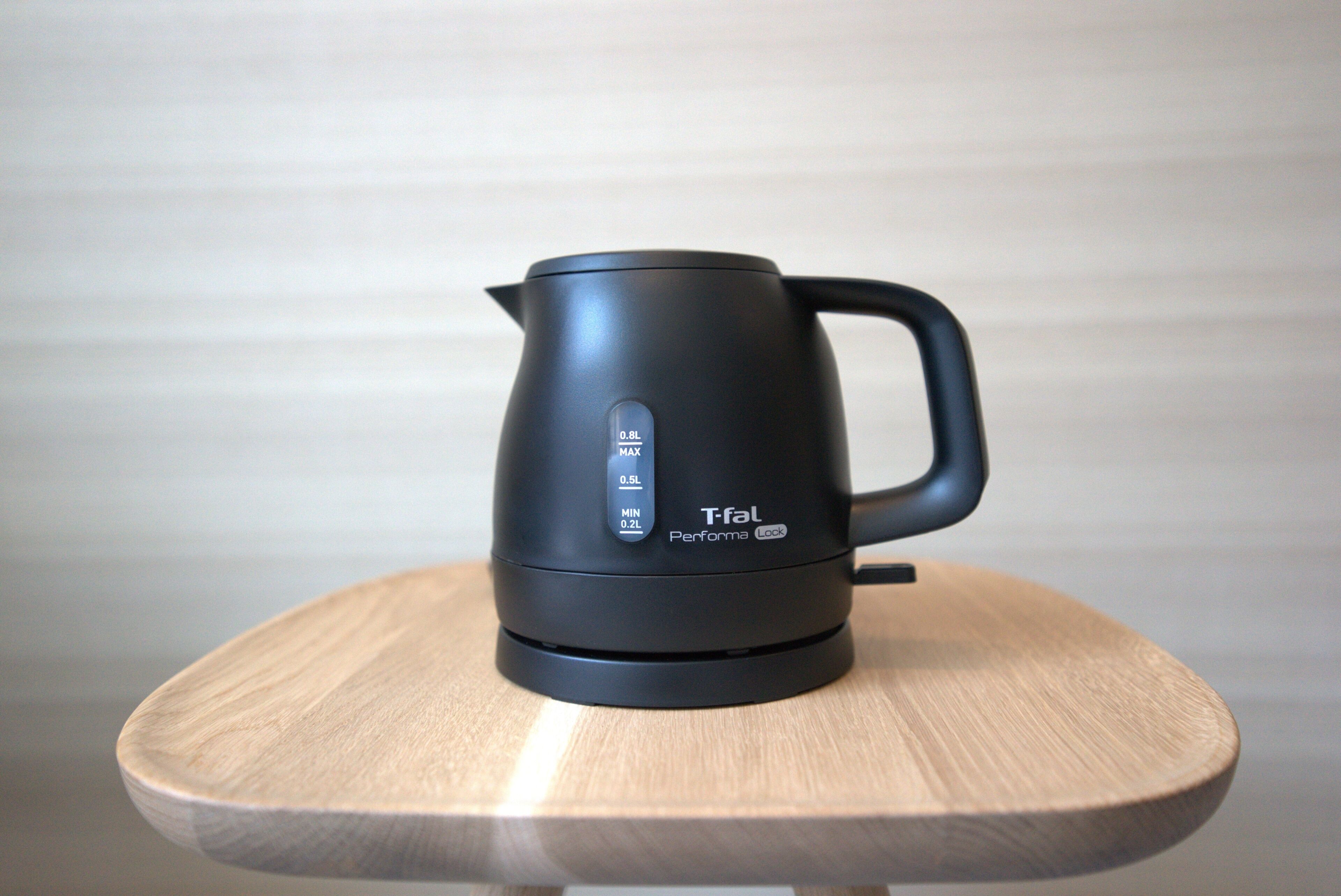 A black Tefal Performa Lock electric kettle on a wooden table.