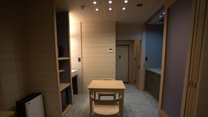 A room with a wooden table and chair, a small white cabinet, and a door in the background. - YUTORIA RESORT HIDATAKAYAMA (Takayama)