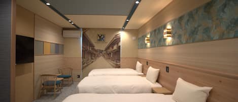 Una habitación de hotel con dos camas, un televisor, una silla y un mural en la pared.