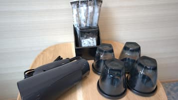 A table with a black device, a set of black cups, and a box of tissues.