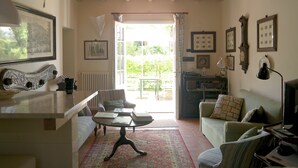 Een ruime woonkamer met een groot raam, een eethoek en een gezellige zithoek.