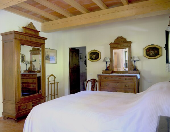 Un dormitorio con una cama grande, muebles de madera y un techo con vigas a la vista.