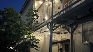 Ein Gebäude mit Balkon, Treppe und einer Tür mit einem Schild.